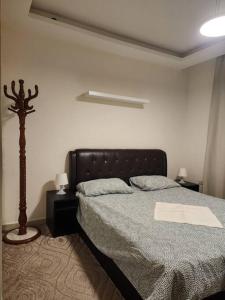 a bedroom with a bed and a lamp in it at SAK Suites in Rujm ash Sharāʼirah