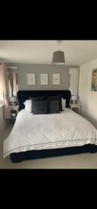 a bedroom with a large bed with white sheets and pillows at 2 bedroom house in Seacroft