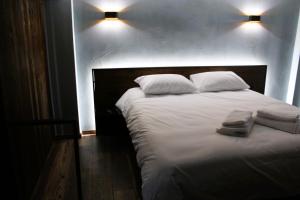 - un grand lit blanc avec 2 serviettes dans l'établissement Wooden Suites, à Thessalonique