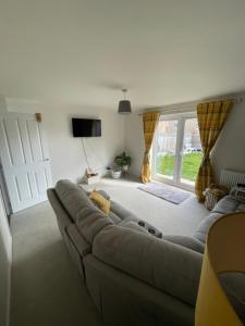 a living room with a couch in front of a window at 2 bedroom house in Seacroft