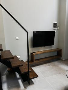 - un salon avec une télévision à écran plat et des escaliers dans l'établissement Wooden Suites, à Thessalonique