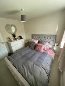 una camera da letto con un letto con cuscini rosa di 2 bedroom house a Seacroft