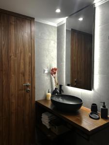 La salle de bains est pourvue d'un lavabo noir et d'un miroir. dans l'établissement Wooden Suites, à Thessalonique