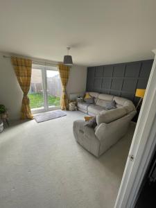 a living room with two couches and a large window at 2 bedroom house in Seacroft
