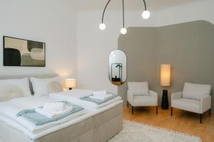 1 dormitorio con 1 cama blanca grande y 2 sillas en Stylish APT for 4-6 metro & walk 5 min to center, en Viena