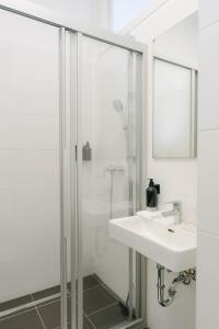 y baño blanco con lavabo y ducha. en Stylish APT for 4-6 metro & walk 5 min to center, en Viena