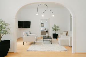 una sala de estar con muebles blancos y un arco en Stylish APT for 4-6 metro & walk 5 min to center, en Viena
