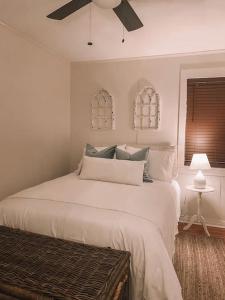 una camera con letto bianco e ventilatore a soffitto di Hub Cottage a Hattiesburg