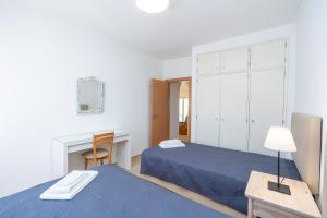 ein Schlafzimmer mit zwei Betten und einem Schreibtisch und einem Tisch in der Unterkunft Quinta Do Torrejao in Armação de Pêra + 23 Fotos
