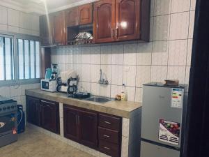 a kitchen with a sink and a refrigerator at Appartement meublé , Bonamoussadi, Douala-Vanguard's signature Suite in Douala