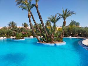 una piscina con palmeras en un complejo en Appartements de charme à la palmeraie, en Marrakech