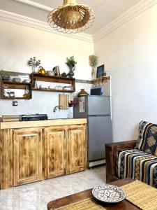 Palmsurfexpo في إمسوان: غرفة معيشة مع ثلاجة وطاولة