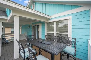 a deck with a wooden table and chairs on a house at Golden Hour on Greenville- 1.5 blocks to beach, Pet Friendly, & No Hidden Fees!! in Carolina Beach