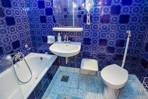 a blue tiled bathroom with a toilet and a sink at Mohacsi Guesthouse in Budapest