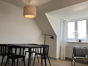 une salle à manger avec une table et des chaises noires dans l'établissement Two-bedroom Apartment Located On The Third Floor Of A Four-story Building In Fredericia, à Fredericia