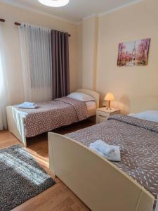 a hotel room with two beds and a window at Anoe City Center Apartment in Shkodër