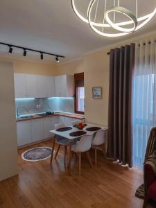 a kitchen and dining room with a table and chairs at Anoe City Center Apartment in Shkodër