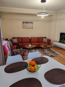a living room with a couch and a bowl of fruit on a table at Anoe City Center Apartment in Shkodër
