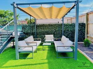 a gazebo with chairs and a table on grass at The Moose #3 - Modern Luxe Studio with Free Gated Parking & Wifi in Memphis