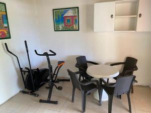 een kamer met een tafel en zwarte stoelen en een tafel en een tafelblad bij Sucasa apartement in Willemstad
