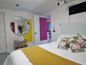 a bedroom with a large bed and a mirror at Flawsome Stays Unique Home w Quirky basement for 12 Guests by Harbour and Town in Ramsgate