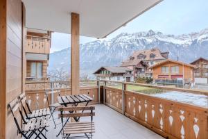 a balcony with chairs and a view of mountains at Chalet Apartments Iseltwald in Iseltwald