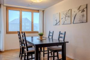 Chalet Apartments Iseltwald في ايسلتوالد: غرفة طعام مع طاولة سوداء وكراسي