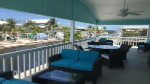 d'un balcon avec des chaises et des tables offrant une vue sur la plage. dans l'établissement Go Fish Inn, à Big Pine Key