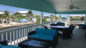 un balcón con sillas y mesas y vistas a la playa en Go Fish Inn, en Big Pine Key