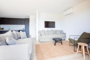 a living room with a white couch and chairs at Super Central in Wanaka in Wanaka