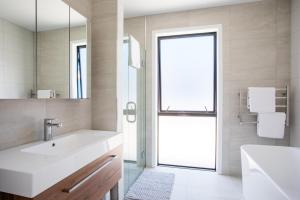 un baño con lavabo y espejo en Super Central in Wanaka, en Wanaka 38 fotos más