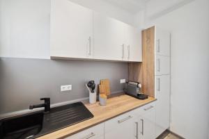 eine Küche mit weißen Schränken und einem Waschbecken in der Unterkunft Ruhige Lage, gute Anbindung, frisch renoviert in Fellbach