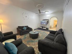 شقة العقيق عروة alaqeeq apartments في المدينة المنورة: غرفة معيشة مع كنبتين وتلفزيون