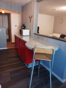 a kitchen with a counter and a table and a microwave at Au doux refuge in Zimmersheim