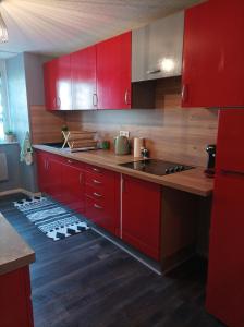 a kitchen with red cabinets and a sink at Au doux refuge in Zimmersheim