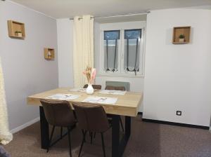 a dining room table and chairs in a room at Au doux refuge in Zimmersheim