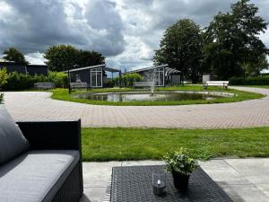 un parque con bancos y un estanque en el medio en Ferienhaus / Chalet / Bungalow am See, Holland, Niederlande, Lathum, en Lathum