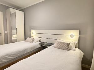 a bedroom with two beds and a mirror at Amelie in Zagreb