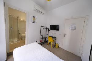 a bedroom with a white bed and a yellow chair at Roman Forum Holiday Termini in Rome