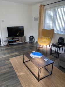 uma sala de estar com uma mesa de centro e uma televisão em 44 Gower holiday village Ty Gŵyr Cosy 2 bedroom Chalet em Swansea