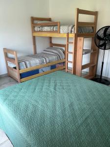 a bedroom with two bunk beds and a green rug at Casa para 7 con pileta y parrilla in El Durazno