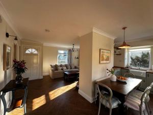 a kitchen and living room with a table and a couch at Sunnybank cottage in Alnwick