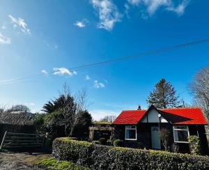 a house with a red roof on top of it at Sunnybank cottage in Alnwick