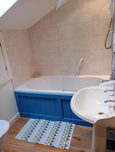 een badkamer met een bad en een wastafel bij Swallow Barn in Llanwrtyd Wells