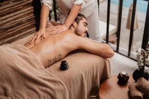 a man getting a massage from a therapist at Hotel B Unique in Cozumel