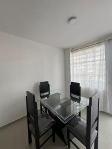 a dining room with a glass table and chairs at CASA AMOBLADA CERCA A LA BASILICA in Club del Comercio