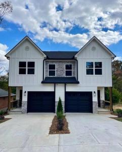 a large white house with two garage doors at NEW Luxury Home Downtown Pet Friendly Fenced Yard in Chattanooga