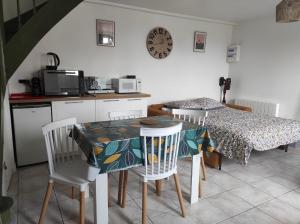 - une cuisine et une salle à manger avec une table et des chaises dans l'établissement la maison du bonheur, à Aleçon