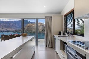 a white kitchen with a view of the mountains at Remarkable Views on Goldrush in Queenstown