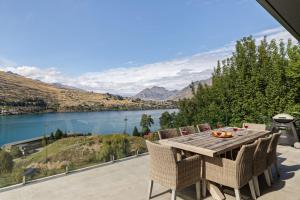 a table with chairs and a view of a lake at Remarkable Views on Goldrush in Queenstown